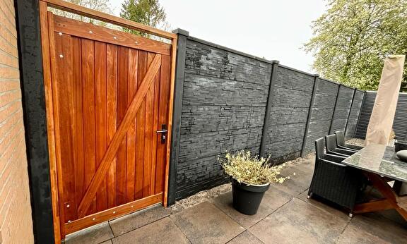 Plaatsen van een betonschutting met hardhouten deur
